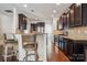 A modern kitchen features dark cabinets, stainless steel appliances, a breakfast bar with stools, and hardwood floors at 241 Catoctin Rd, Rock Hill, SC 29732