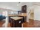 Kitchen featuring dark cabinets, granite countertops, a central island, and views of the adjacent living area and staircase at 241 Catoctin Rd, Rock Hill, SC 29732