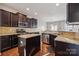 Kitchen featuring dark cabinets, granite countertops, stainless steel appliances, a central island, and hardwood floors at 241 Catoctin Rd, Rock Hill, SC 29732