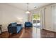 Sunlit living room with hardwood floors, features a sliding glass door with backyard views and blue armchairs at 241 Catoctin Rd, Rock Hill, SC 29732