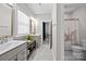Bright bathroom with dual vanities, updated lighting, and a view into the shower room at 2419 Paddlers Cove Dr, Clover, SC 29710