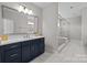 Modern bathroom with a navy blue vanity, a large mirror, and a glass-enclosed walk-in shower at 2419 Paddlers Cove Dr, Clover, SC 29710