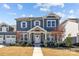 Charming two-story home featuring covered porch with stone accents and landscaped front yard at 2419 Paddlers Cove Dr, Clover, SC 29710