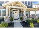 Inviting front porch with stone columns and seating area offers a welcoming entrance to the home at 2419 Paddlers Cove Dr, Clover, SC 29710