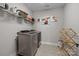 Functional laundry room with modern washer and dryer units, storage shelving, and decor at 2419 Paddlers Cove Dr, Clover, SC 29710