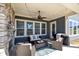 Cozy covered patio with a stone fireplace, ceiling fan, and comfortable seating area perfect for outdoor relaxation at 2419 Paddlers Cove Dr, Clover, SC 29710