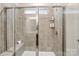 Modern bathroom shower featuring tiled walls, a built-in bench, and glass doors at 2534 Crimson Way, Monroe, NC 28112