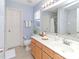 Well-lit bathroom with a white countertop, wooden cabinets and decorative mirror at 2627 Bridgeville Ln, Charlotte, NC 28262