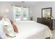 Bright bedroom with large windows, plush bedding and dresser with mirror at 2627 Bridgeville Ln, Charlotte, NC 28262
