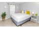Bright bedroom with white bedding, yellow pillows, and tile flooring at 2627 Bridgeville Ln, Charlotte, NC 28262