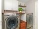 Bright laundry room with modern washer and dryer units, floating shelves, and custom storage solutions at 2627 Bridgeville Ln, Charlotte, NC 28262