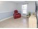 Relaxing living room featuring a comfortable leather recliner, a sunny window and neutral tile floors at 2627 Bridgeville Ln, Charlotte, NC 28262