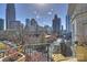 Balcony view showcasing city skyline, street, and green park areas below at 300 W 5Th St # 711, Charlotte, NC 28202