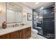 Modern bathroom features a wood vanity with a marble countertop and a tiled walk-in shower at 300 W 5Th St # 711, Charlotte, NC 28202