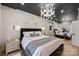 Elegant bedroom with a dark ceiling, modern chandelier, large bed, and mirrored wall at 300 W 5Th St # 711, Charlotte, NC 28202