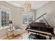 Sunlit music room features a grand piano, seating, chandelier, and windows with city views at 300 W 5Th St # 711, Charlotte, NC 28202