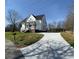 A white two-story home with a long concrete driveway and a covered front porch at 320 City Ave, Lancaster, SC 29720