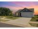 Single-story home featuring a two-car garage and well-manicured front lawn at sunset at 324 Aniston Ln, Shelby, NC 28152