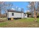 Exterior view of a house with a spacious backyard, showing the home's clean white siding and dark trim at 345 Grice St, Shelby, NC 28150