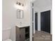 Bathroom features a sliding barn-style vanity, modern light fixture, and contrasting black door and trim at 345 Grice St, Shelby, NC 28150
