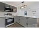 Bright kitchen features gray cabinets, stainless appliances, white counters, and new pendant lighting at 345 Grice St, Shelby, NC 28150