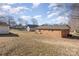 Backyard featuring a grassy area, brick home and a storage shed at 437 Valley St, Stanley, NC 28164