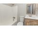 Bright bathroom featuring a tub with shower, toilet, wood-grain vanity and framed mirror at 437 Valley St, Stanley, NC 28164