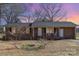 Charming brick home with a covered front porch, rocking chairs, and an American flag at 437 Valley St, Stanley, NC 28164