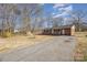 Brick home with a covered front porch, rocking chairs, American flag, and long driveway at 437 Valley St, Stanley, NC 28164