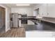 Bright kitchen with stainless steel appliances, vinyl flooring, white cabinets, and dark countertops at 437 Valley St, Stanley, NC 28164