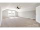 Spacious bonus room featuring plush carpet, a ceiling fan, and plenty of natural light from the double windows at 453 Cedar Grove Rd, Clover, SC 29710