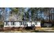 Cozy single-story home featuring white siding, dark shutters, and a brick foundation, nestled amongst a mature tree line at 4946 A Tinkers Creek Rd, Edgemoor, SC 29712