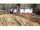 View of the backyard featuring a well-maintained lawn, mature trees, and partial fencing at 5124 Gates Dr, Denver, NC 28037