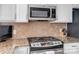 Close-up of kitchen stove, microwave, and granite countertops at 582 Sixth Baxter Xing, Fort Mill, SC 29708