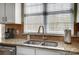 Close-up of kitchen sink with stainless faucet, granite countertops, and a window at 582 Sixth Baxter Xing, Fort Mill, SC 29708