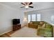 Charming living room with a plush green sectional sofa, TV, ceiling fan, and large windows at 582 Sixth Baxter Xing, Fort Mill, SC 29708