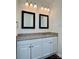 Bathroom featuring granite countertop, modern vanity, and dual black-framed mirrors at 5905 Waverly Lynn Ln, Charlotte, NC 28269