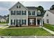 Two-story home with gray siding, brick accents, and complementary green shutters and front door at 5905 Waverly Lynn Ln, Charlotte, NC 28269