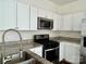 White cabinets and stainless steel appliances enhance this well-lit kitchen space with a granite counter at 5905 Waverly Lynn Ln, Charlotte, NC 28269