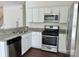 Modern kitchen with stainless steel appliances, granite countertops, and white cabinetry, perfect for cooking enthusiasts at 5905 Waverly Lynn Ln, Charlotte, NC 28269