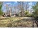A spacious backyard features a well-kept lawn, mature trees, and a charming fence at 6817 Fieldlark Ln, Charlotte, NC 28227