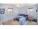 Comfortable bedroom with carpet flooring, two windows providing natural light, and a ceiling fan at 6817 Fieldlark Ln, Charlotte, NC 28227