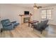 Comfortable living room featuring a stone fireplace, ceiling fan, and natural light at 6817 Fieldlark Ln, Charlotte, NC 28227
