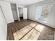 Cozy bedroom showcasing wood-look floors, a large window, and ample closet space at 7140 Stonington Ln, Charlotte, NC 28227