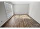 Sunlit bedroom featuring a large window and wood-look flooring for a warm and inviting ambiance at 7140 Stonington Ln, Charlotte, NC 28227