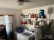 Functional laundry room with modern washer, dryer, shelving, and hot water heater for added convenience at 7426 Riding Trail Rd, Charlotte, NC 28212
