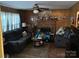 Cozy living room features wood paneling, a brick fireplace, and comfortable seating for relaxing and entertaining at 7426 Riding Trail Rd, Charlotte, NC 28212