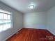 Inviting bedroom with a window offering ample natural light and gleaming hardwood floors at 7515 Riding Trail Rd, Charlotte, NC 28212