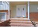 Welcoming front entrance with double doors, brick steps, and classic architectural details at 7515 Riding Trail Rd, Charlotte, NC 28212