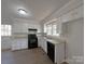 Traditional kitchen featuring white cabinetry, black appliances, and a window over the sink at 7515 Riding Trail Rd, Charlotte, NC 28212
